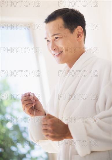 Mid adult man mixing herbal tea. Photo : Daniel Grill