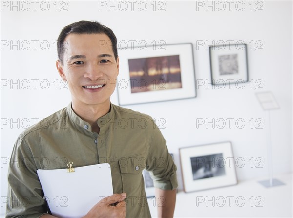 Gallery worker posing in front of newly hanged paintings. Photo : Daniel Grill