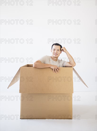 Man sitting in cardboard box. Photo : Daniel Grill