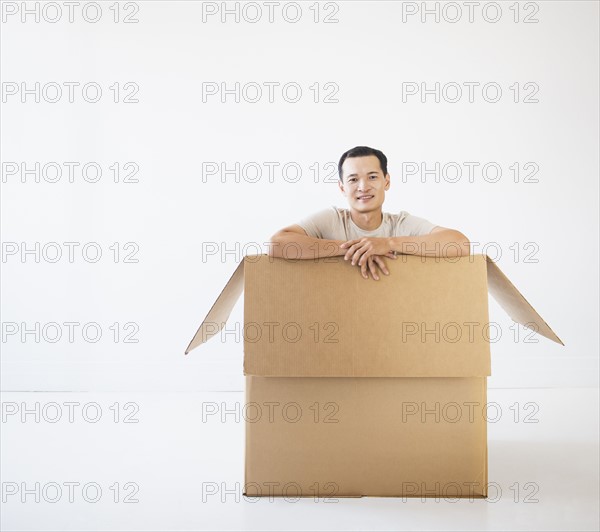 Man sitting in cardboard box. Photo : Daniel Grill