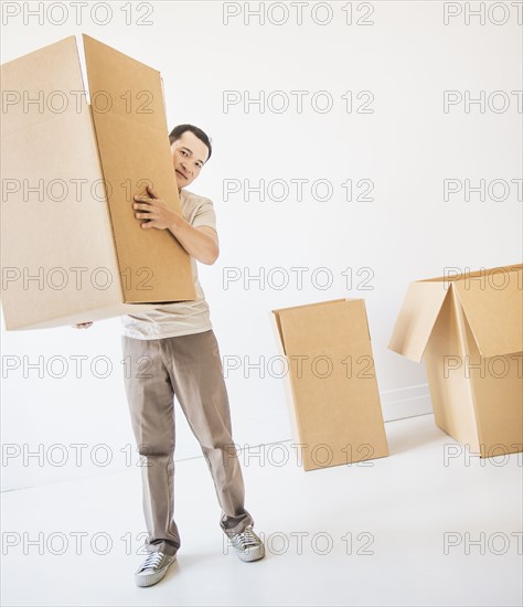 Mid adult moving cardboard boxes. Photo : Daniel Grill