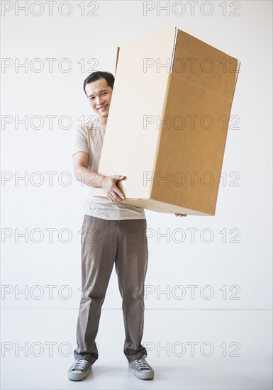 Mid adult moving cardboard boxes. Photo : Daniel Grill