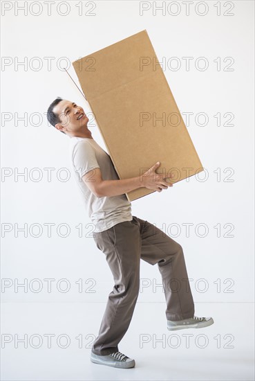 Mid adult moving cardboard heavy box. Photo: Daniel Grill