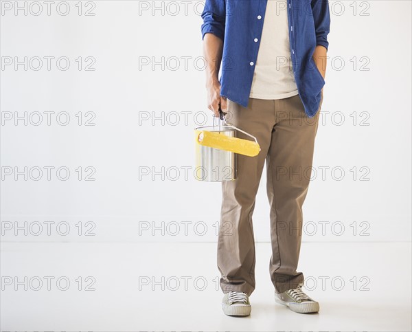 Man holding painting roll. Photo : Daniel Grill