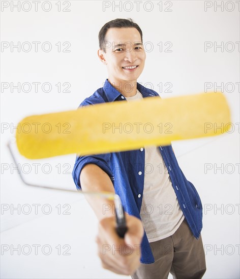 Man holding painting roll. Photo : Daniel Grill