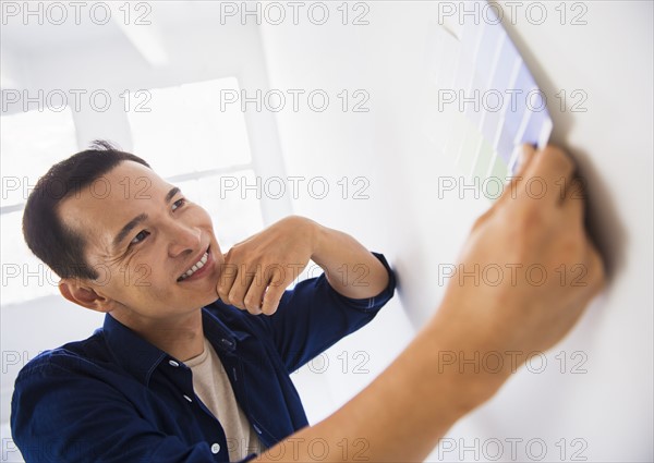 Man applying paint samples to white wall. Photo : Daniel Grill