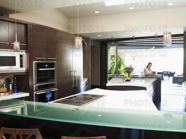 Young woman bustling around in modern domestic kitchen.