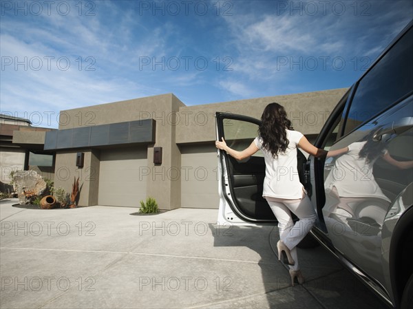 Young woman getting in car.