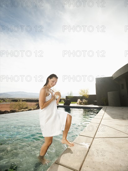 Young attractive woman emerging from swimming pool.