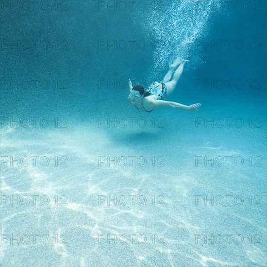 Young attractive woman diving in swimming pool.