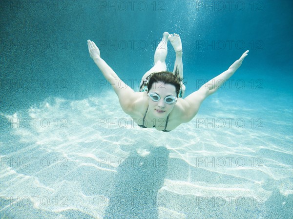 Young attractive woman diving in swimming pool. Photo: Erik Isakson