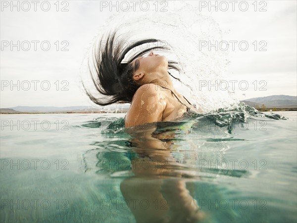 Attractive young woman emerging from swimming pool. Photo: Erik Isakson