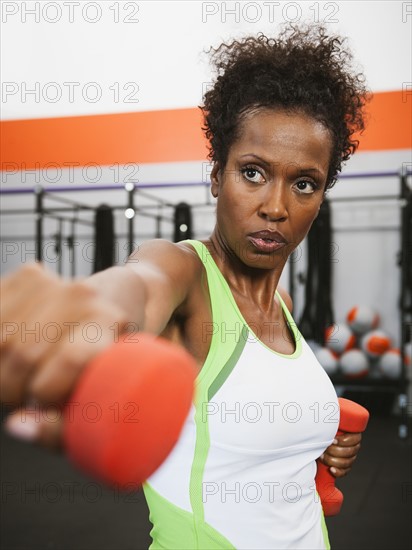 Mid adult woman exercising with dumbbells.