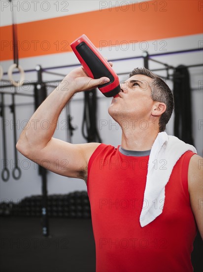 Mature man drinking while taking break from exercising. Photo: Erik Isakson