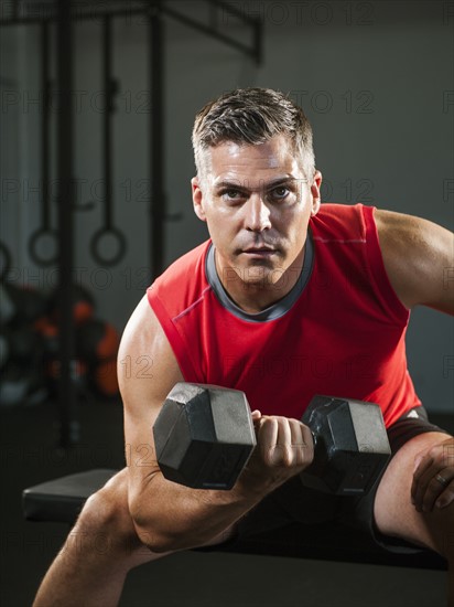 Mature man exercising with dumbbells.