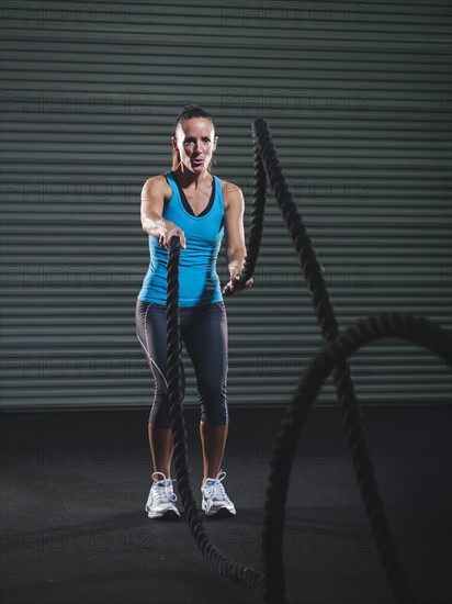 Mid adult woman exercising with rope.