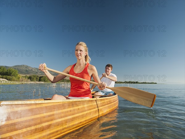 Portrait of two young people paddling canoe. Photo: Erik Isakson
