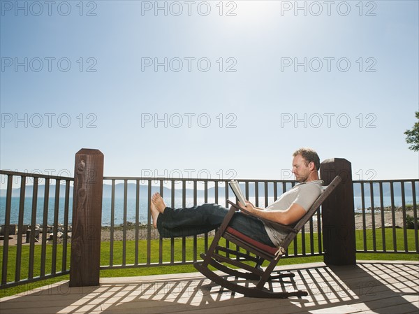 Mid-adult man relaxing on rocking chair. Photo: Erik Isakson