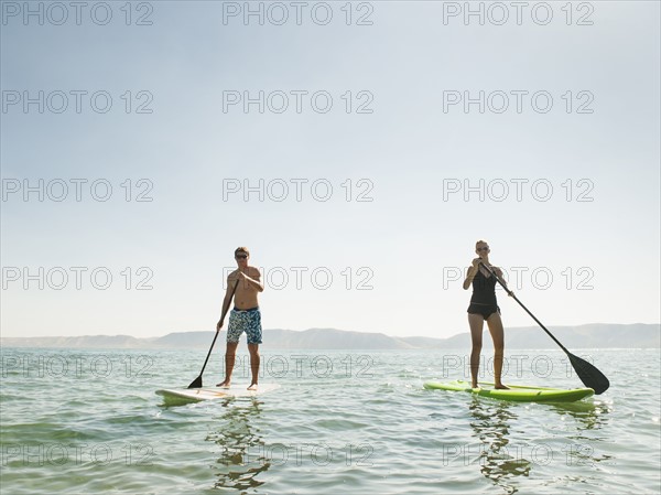 Two people standing on paddleboard.