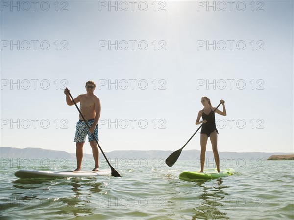 Two people standing on paddleboard.