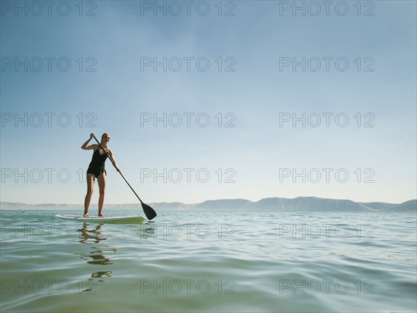 Young woman standing on paddleboard. Photo: Erik Isakson