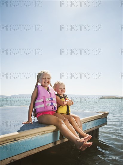 Girls (2-3, 4-5) sitting at the edge of raft in life jackets. Photo: Erik Isakson