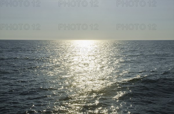 sunlight reflecting on sea. Photo : Tetra Images