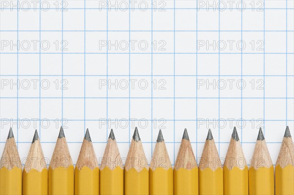 Row of sharpened pencils on graph paper, studio shot. Photo : Kristin Duvall