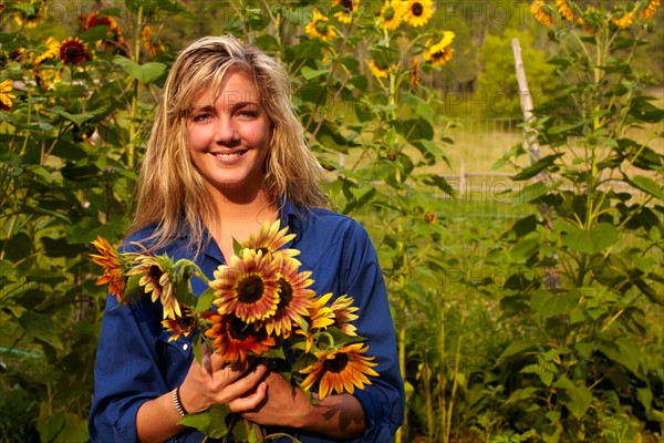 Woman holding bouquet of sunflowers. Photo: John Kelly
