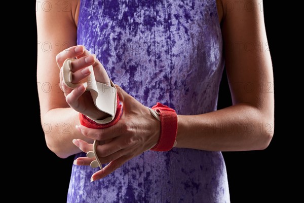 Close-up of gymnast adjusting grips on hands. Photo : Mike Kemp