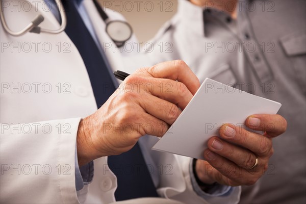 Close-up of doctor writing prescription for patient. Photo: Mike Kemp