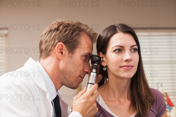 Doctor performing hearing test with Otoscope. Photo : Mike Kemp