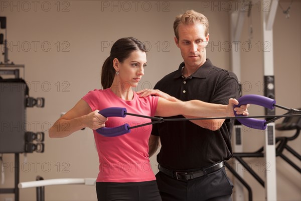 Young woman exercising with help from physical therapist. Photo: Mike Kemp