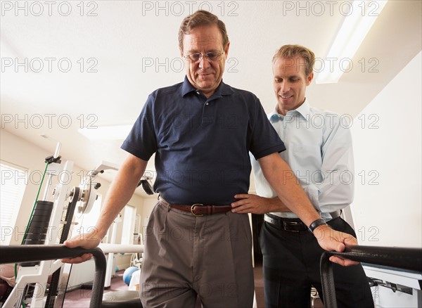 Man re-learning to walk with physical therapist. Photo : Mike Kemp