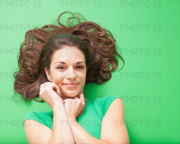Beauty shot of girl laying on green background. Photo : Mike Kemp