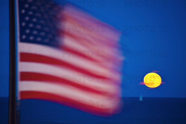 Flag and rising moon over Lake Michigan. Photo: Henryk Sadura