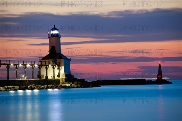 Michigan City Lighthouse at sunset. Chicago skyscrapers seen far in background.. Photo: Henryk Sadura