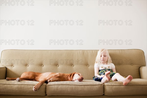 Girl (4-5 years) on couch with dog. Photo: Jessica Peterson