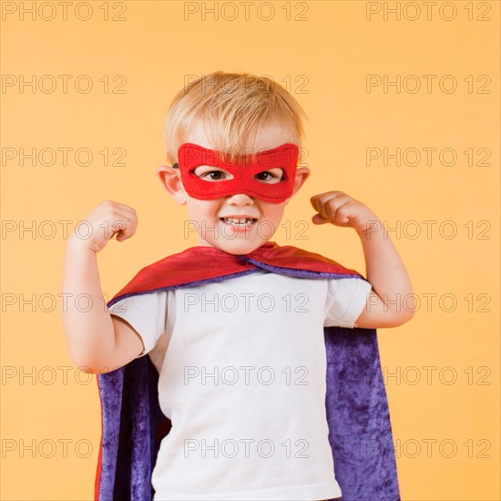 Studio shot, Portrait of smiling boy (2-5 years) showing his strenght. Photo : Jessica Peterson