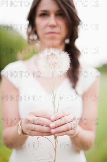 Woman holding dandelion. Photo : Jessica Peterson