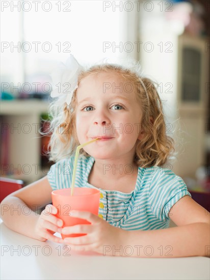 Portrait of girl drinking through straw. Photo: Jessica Peterson