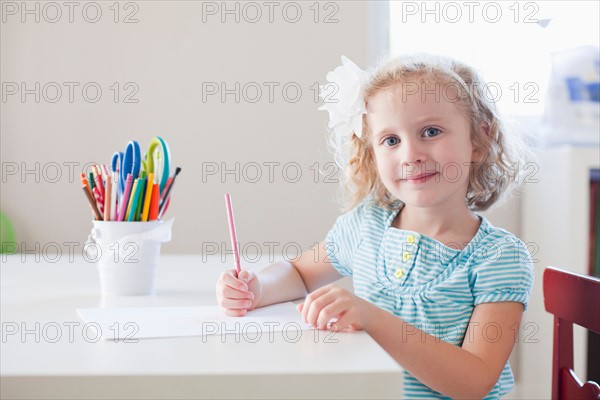 Girl sitting at table and looking at camera. Photo: Jessica Peterson
