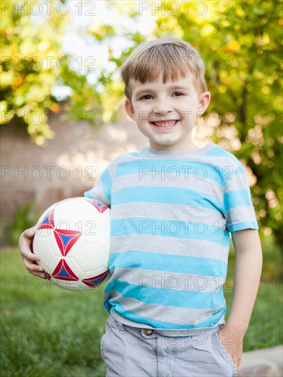 Boy smiling and holding soccer ball. Photo: Jessica Peterson