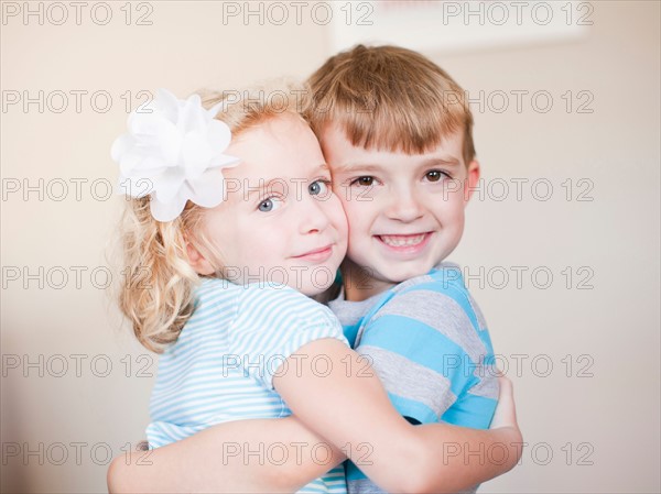 Studio Shot, Portrait of sister and brother hugging each other. Photo: Jessica Peterson