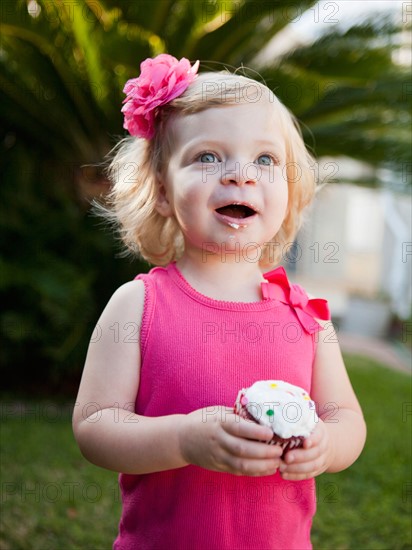 Girl holding cupcake. Photo : Jessica Peterson