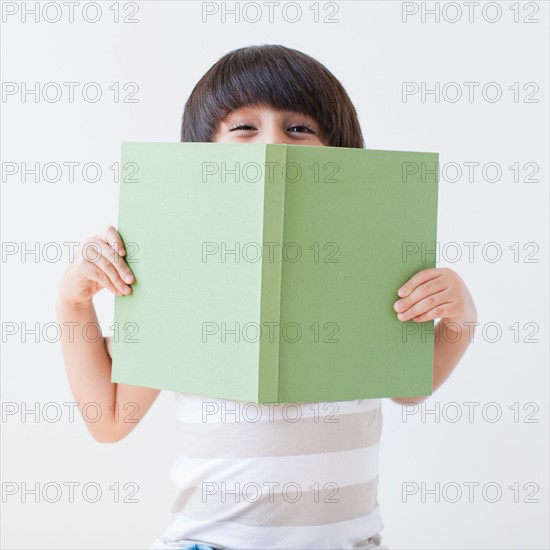 Studio Shot of young boy holding book. Photo: Jessica Peterson