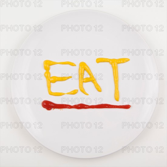 Word EAT written with mustard and ketchup. Photo : Jessica Peterson