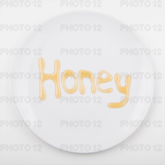 Word HONEY on white plate. Photo : Jessica Peterson