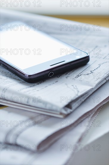 Smartphone on newspaper.