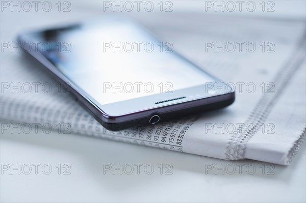 Smartphone on newspaper.